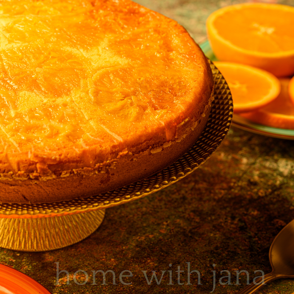 Round Clementine Cake, garnished with fresh clementines.