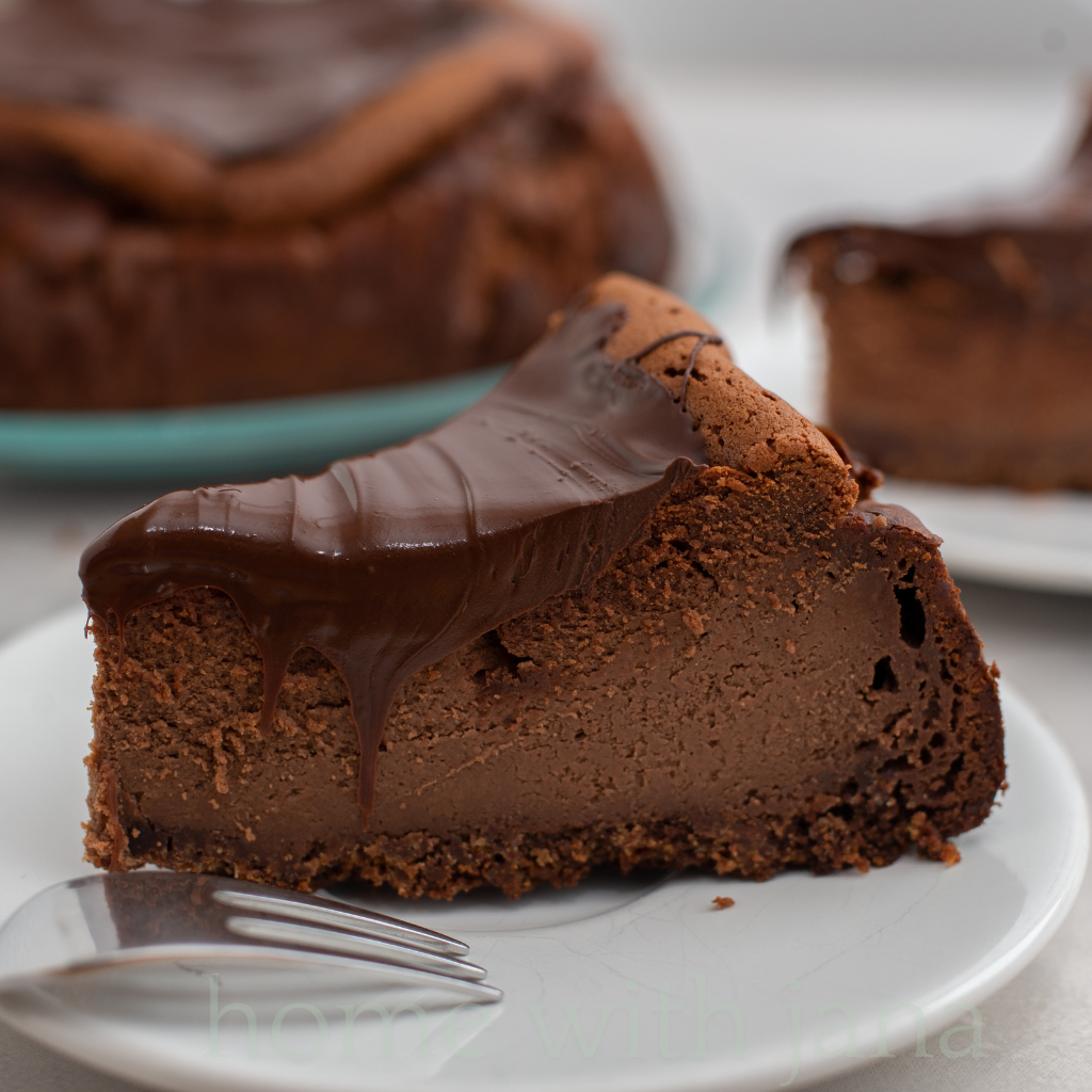 A beautifully plated Irish Cream Chocolate Cheesecake with a smooth chocolate ganache