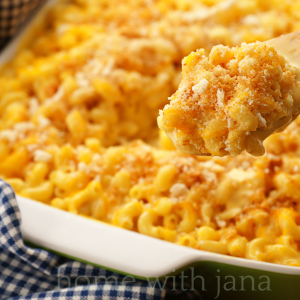 Golden, cheesy Southern-style baked mac and cheese served in a white casserole dish set in a cozy kitchen with warm lighting.