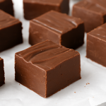 Freshly made chocolate fudge cut into squares and arranged on parchment paper