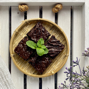 Fudgy Chocolate Drizzle Brownies with a mint garnish on a white board.