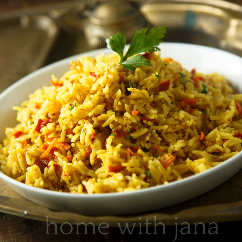 Bowl of fluffy seasoned yellow rice with turmeric, carrots, and herbs