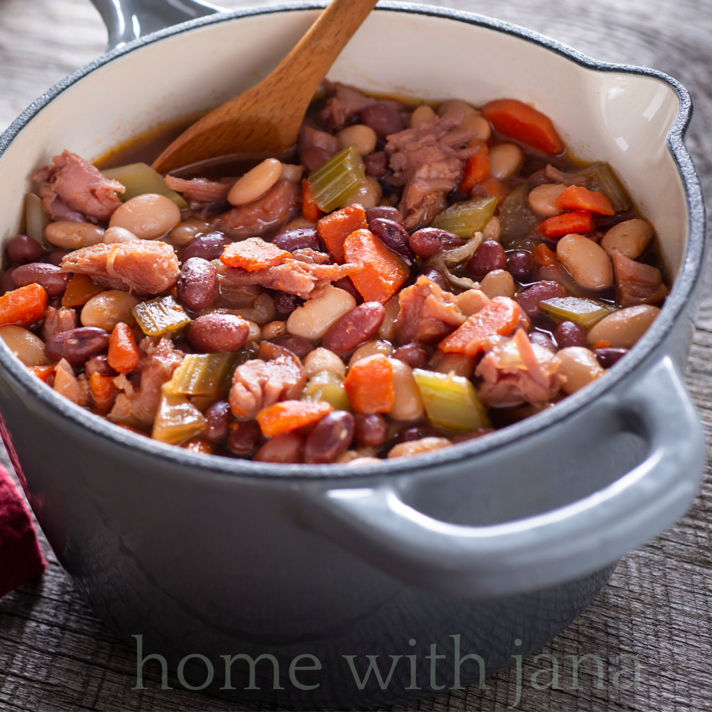 Homemade ham and bean soup in a Dutch oven with carrots, celery, and tender ham pieces