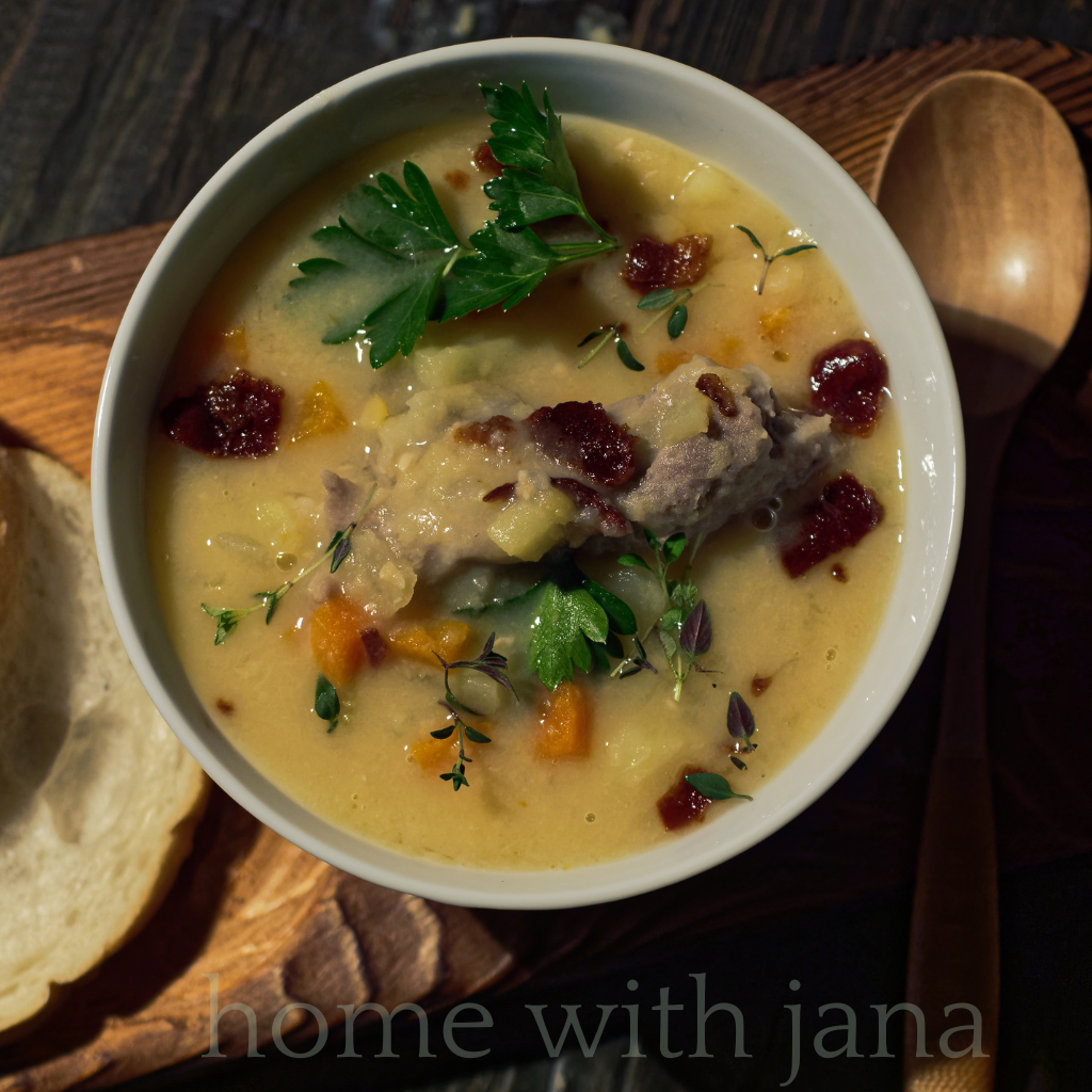 Bowl of homemade split pea soup with ham, carrots, potatoes, and parsley garnish