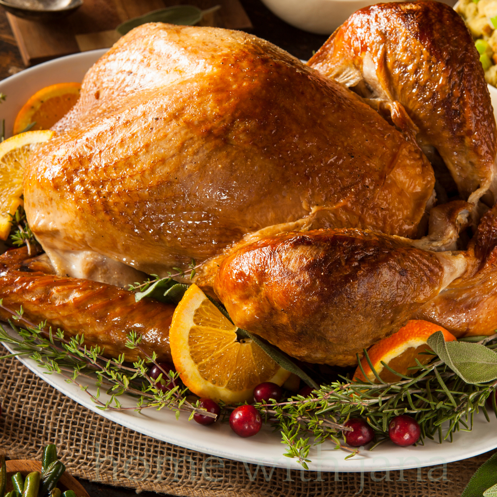 Golden roasted Thanksgiving turkey garnished with oranges, cranberries, and fresh herbs on a holiday platter.