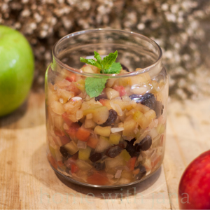 Homemade Sweet Apple Relish with raisins and diced apples in a glass jar, perfect for canning and serving with meats, sandwiches, or cheese boards.
